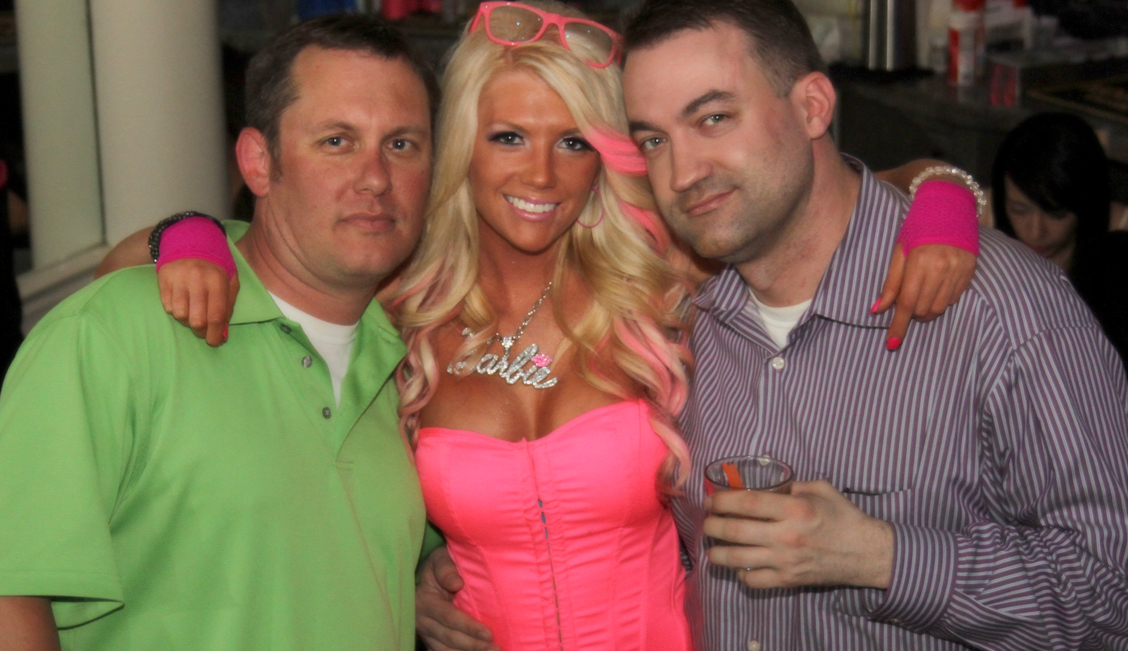 Barbie pink blonde posing with two happy men in the Baton Rouge strip club - The Penthouse Club